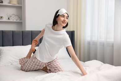 Young woman exercising on bed at home. Morning routine