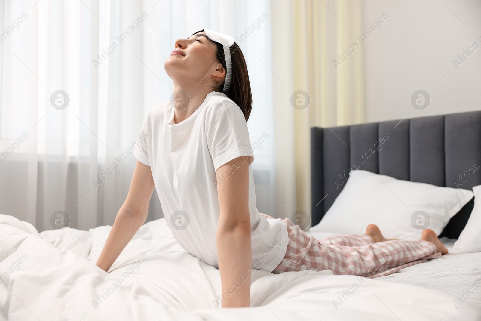 Photo of Young woman exercising on bed at home. Morning routine