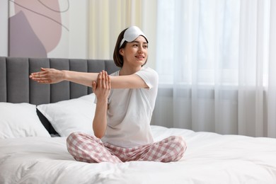 Photo of Young woman exercising on bed at home. Morning routine