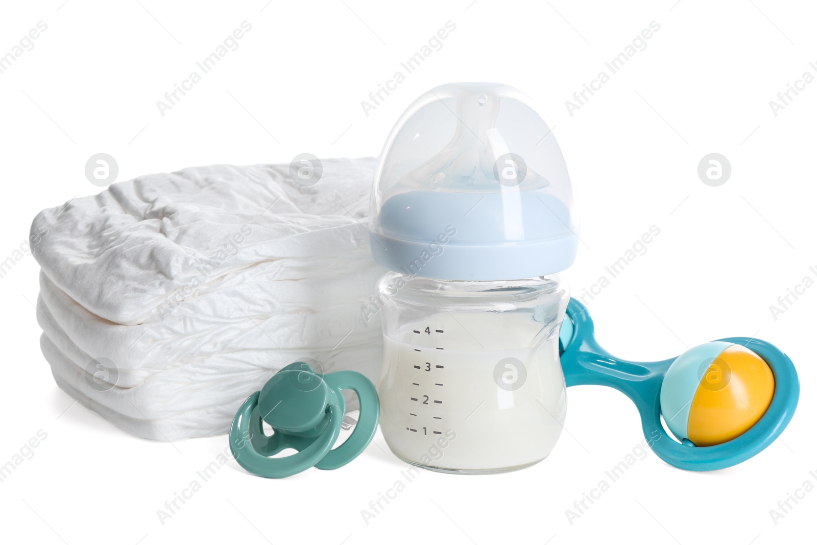 Photo of Feeding bottle with milk, diapers, baby rattle and pacifier isolated on white