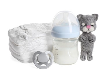 Feeding bottle with milk, needle felted cat and pacifier isolated on white