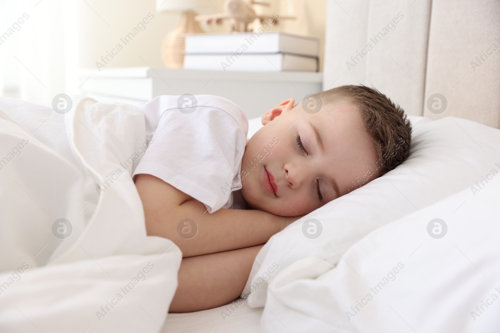 Photo of Bedtime. Cute boy sleeping in comfortable bed