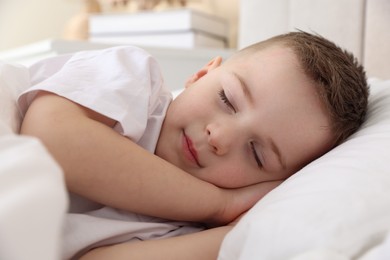 Photo of Bedtime. Cute boy sleeping in comfortable bed