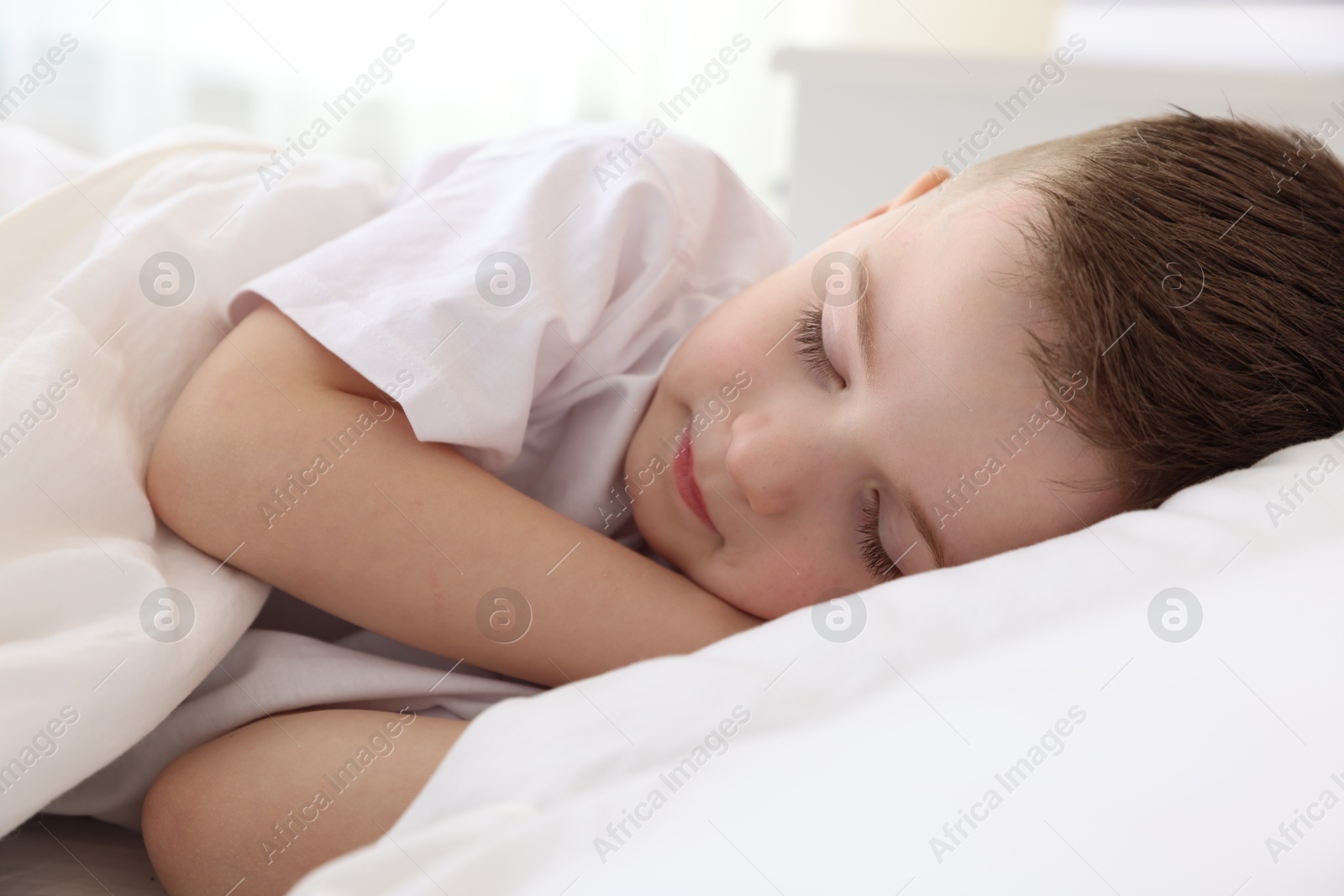 Photo of Bedtime. Cute boy sleeping in comfortable bed