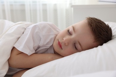 Photo of Bedtime. Cute boy sleeping in comfortable bed