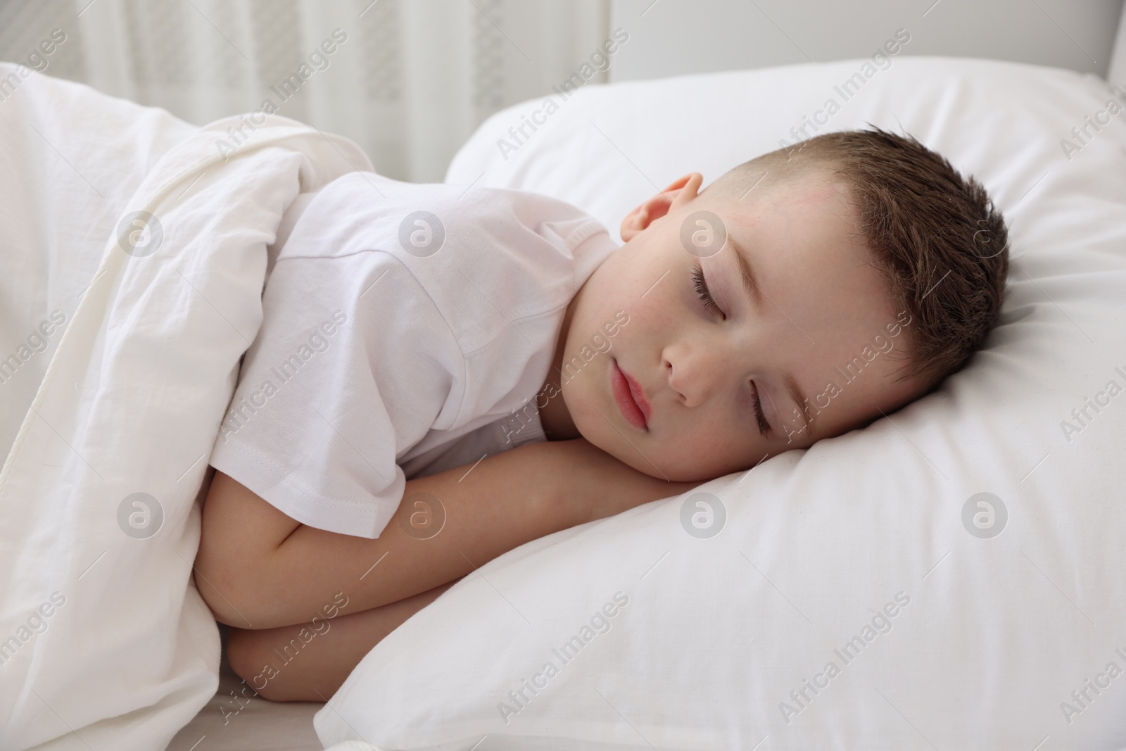 Photo of Bedtime. Cute boy sleeping in comfortable bed