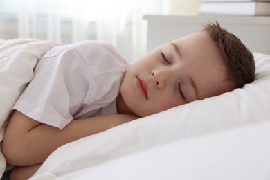 Photo of Bedtime. Cute boy sleeping in comfortable bed