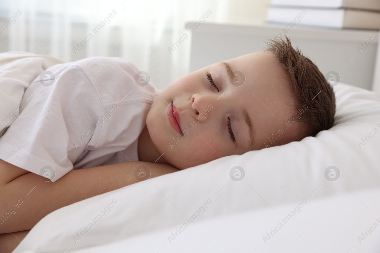 Photo of Bedtime. Cute boy sleeping in comfortable bed