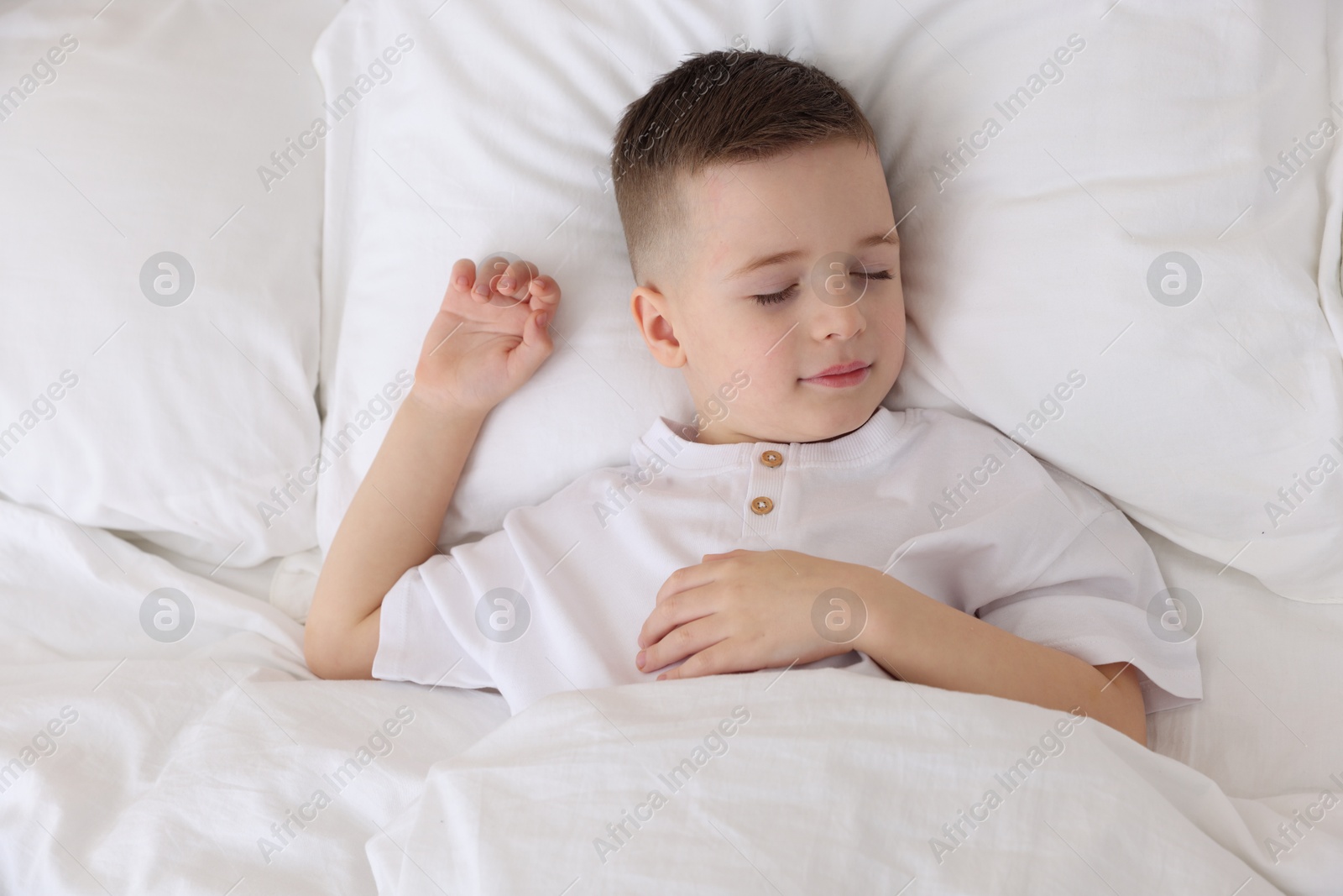 Photo of Bedtime. Cute boy sleeping in comfortable bed