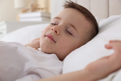 Photo of Bedtime. Cute boy sleeping in comfortable bed