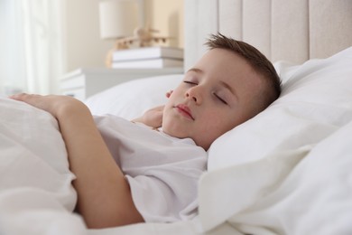 Photo of Bedtime. Cute boy sleeping in comfortable bed