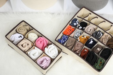 Photo of Organizers with different socks on carpet indoors, above view