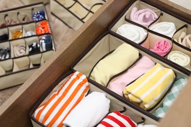 Photo of Organizers with folded clothes in drawer indoors, above view