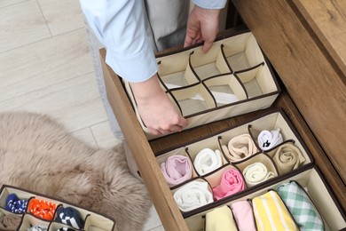 Photo of Woman putting empty organizer into drawer at home, above view