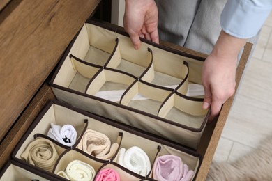 Photo of Woman putting empty organizer into drawer at home, above view