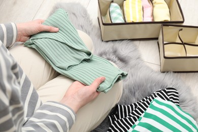 Photo of Woman organizing clothes on floor at home, above view