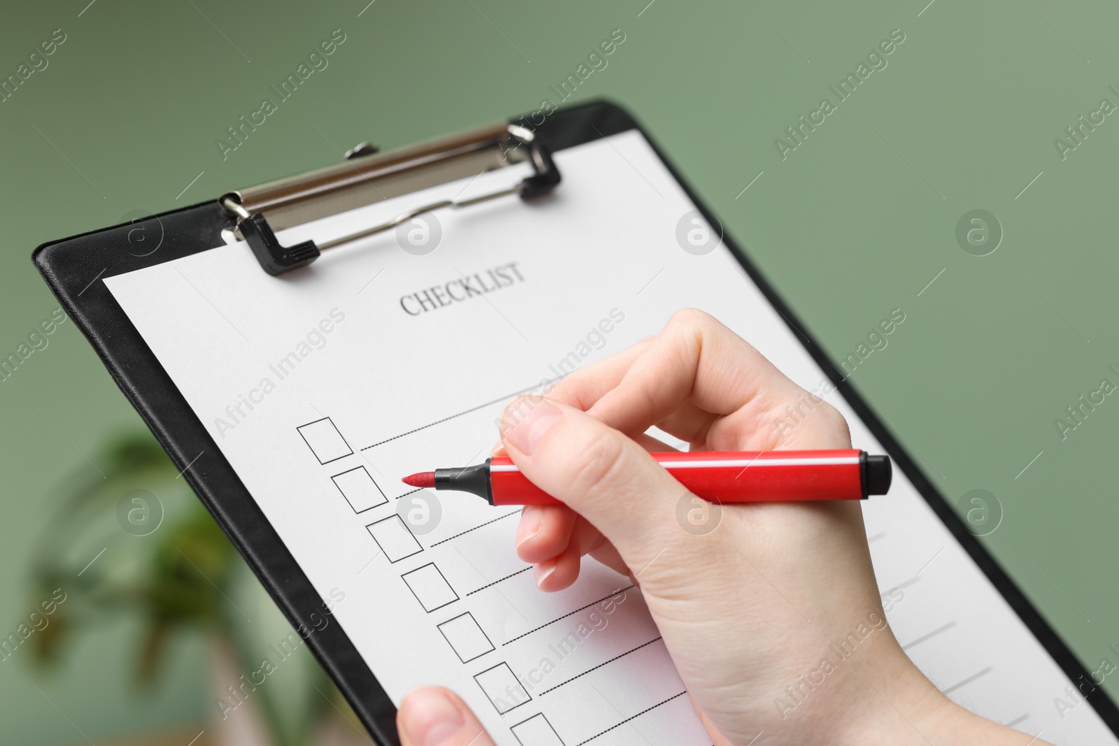 Photo of Woman filling Checklist with marker indoors, closeup