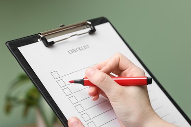 Photo of Woman filling Checklist with marker indoors, closeup