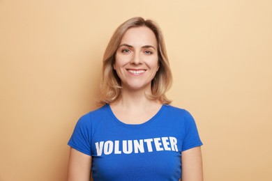 Photo of Portrait of happy volunteer on beige background