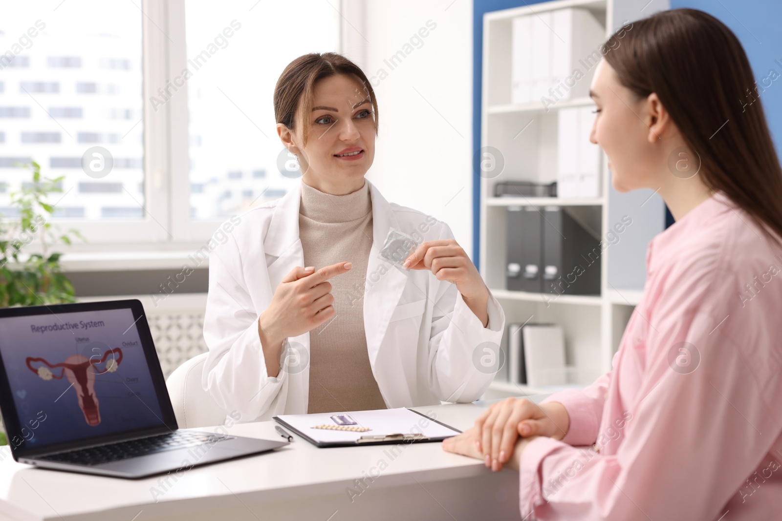 Photo of Contraception. Gynecologist recommending condom to woman in clinic