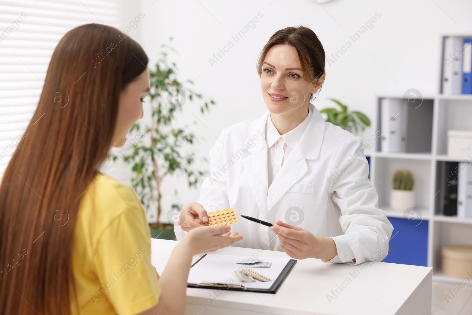 Photo of Gynecologist recommending contraceptive pills to woman in clinic