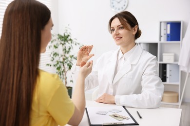 Contraception. Gynecologist recommending vaginal ring to woman in clinic