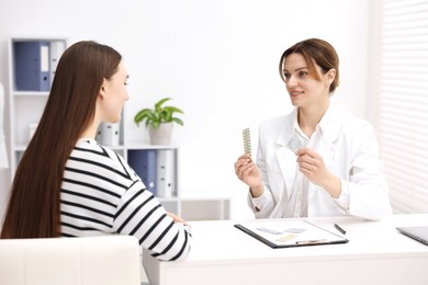 Photo of Gynecologist showing different contraceptive products to woman in clinic