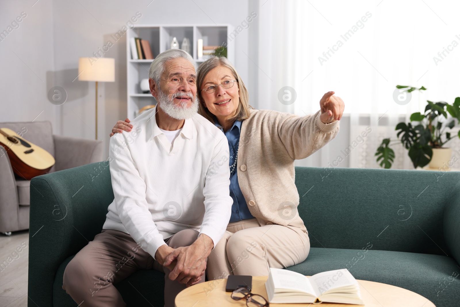 Photo of Happy elderly couple on sofa at home