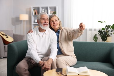 Photo of Happy elderly couple on sofa at home