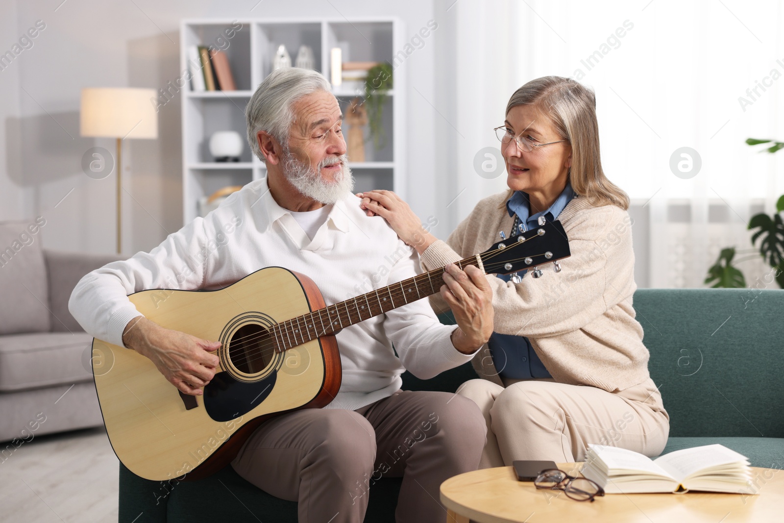 Photo of Cute elderly couple spending time together on sofa at home