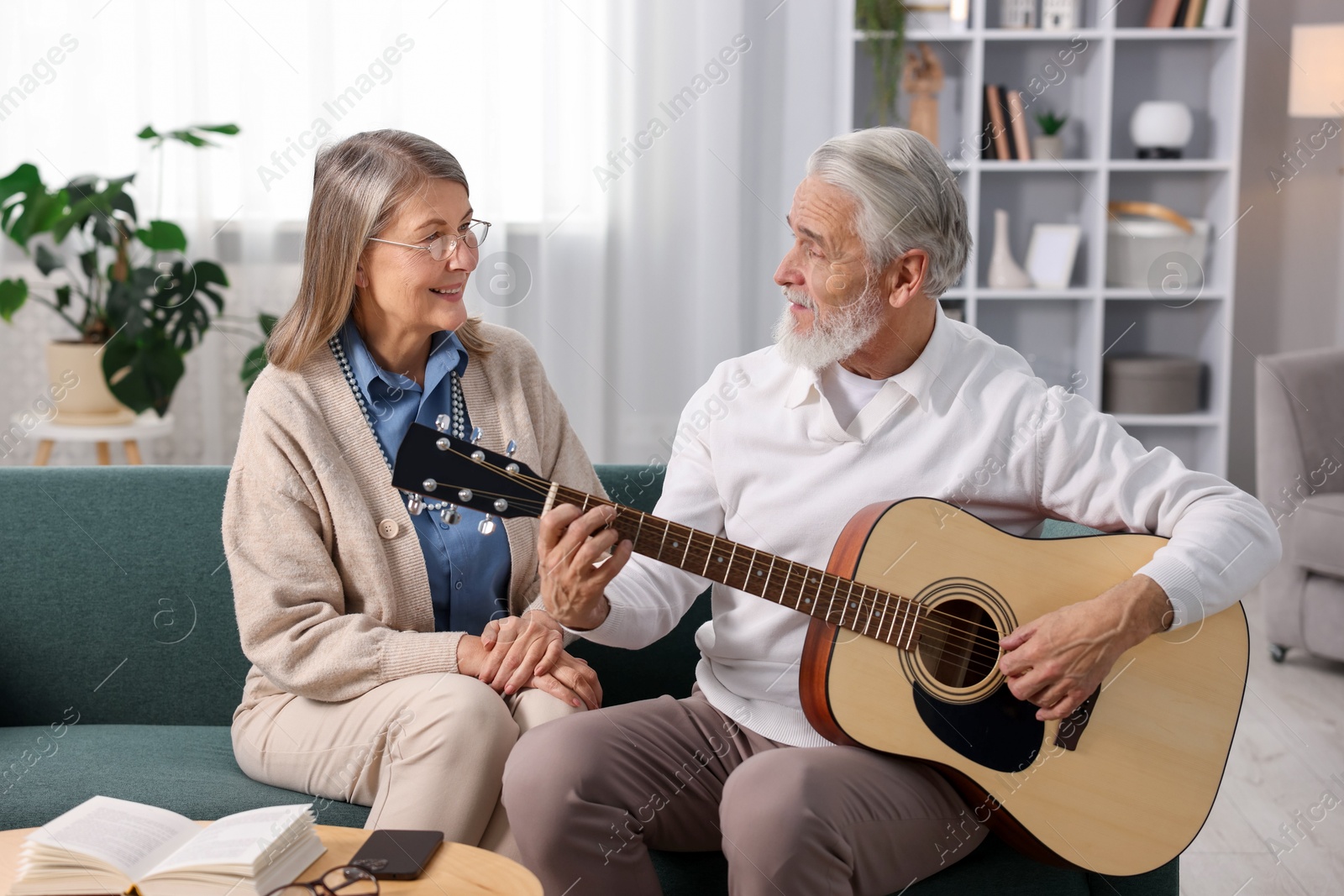 Photo of Cute elderly couple spending time together on sofa at home