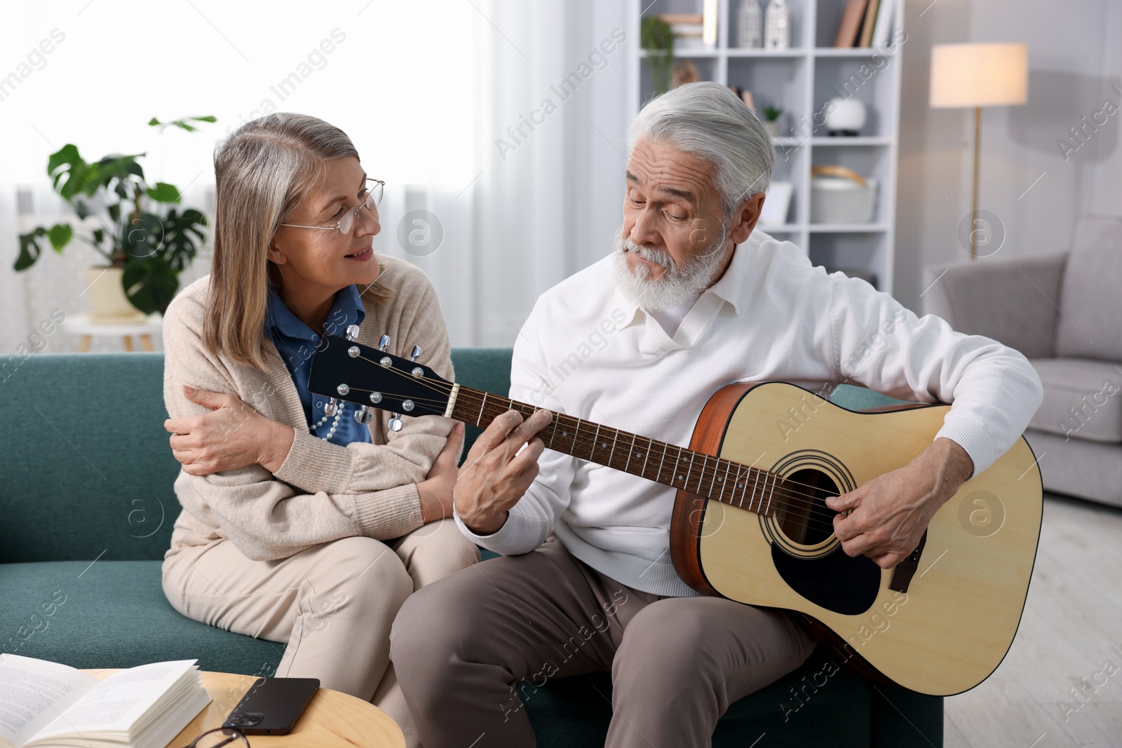 Photo of Cute elderly couple spending time together on sofa at home