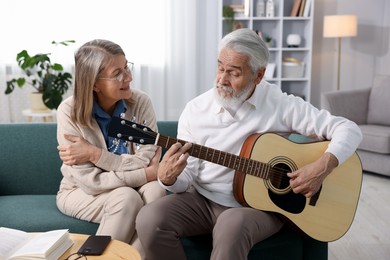 Cute elderly couple spending time together on sofa at home