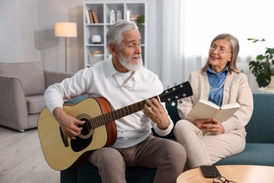 Photo of Cute elderly couple spending time together on sofa at home