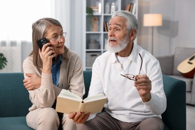 Cute elderly couple spending time together on sofa at home