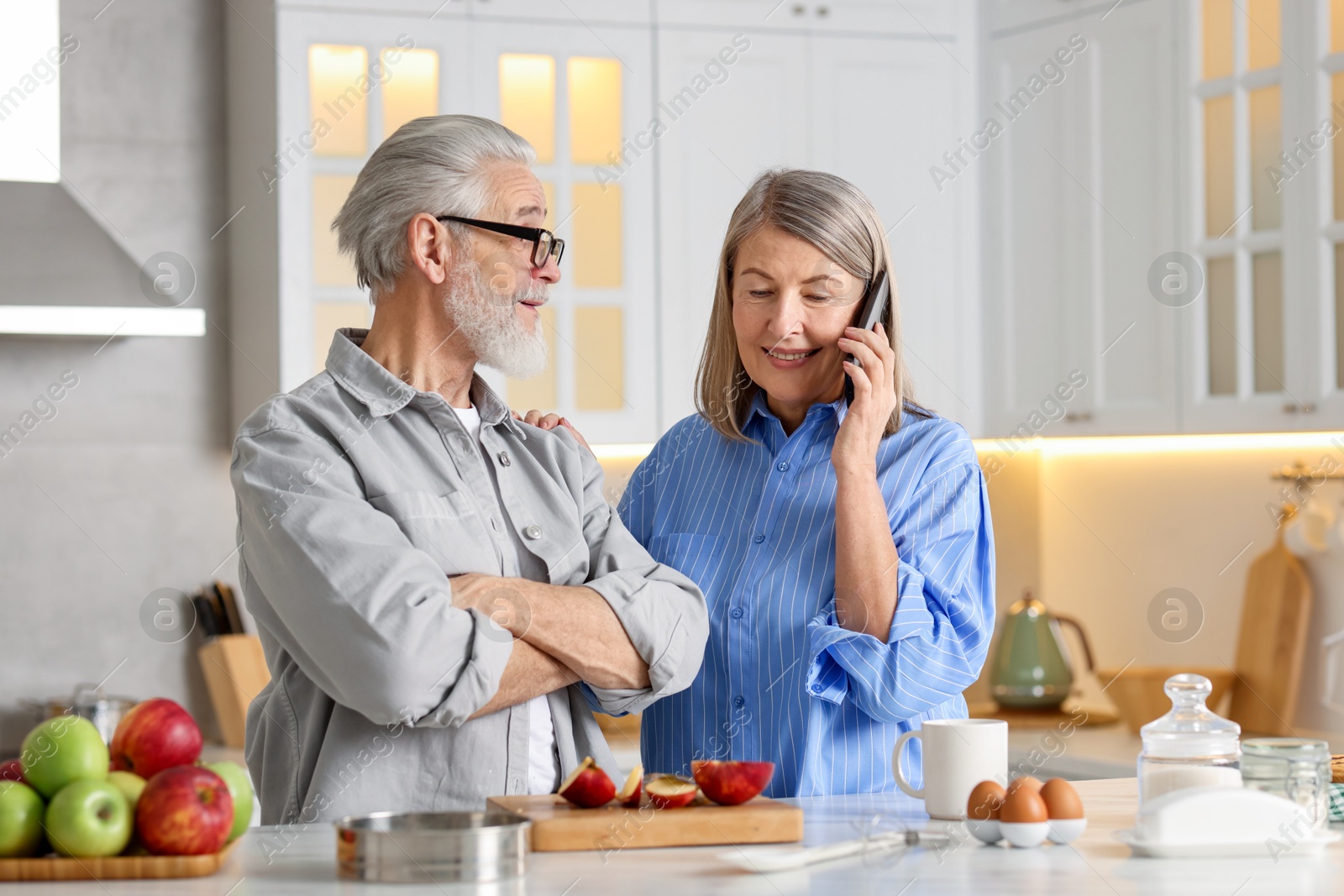 Photo of Cute elderly couple spending time together at table in kitchen