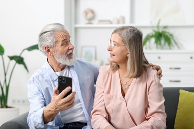 Happy elderly couple looking at each other at home