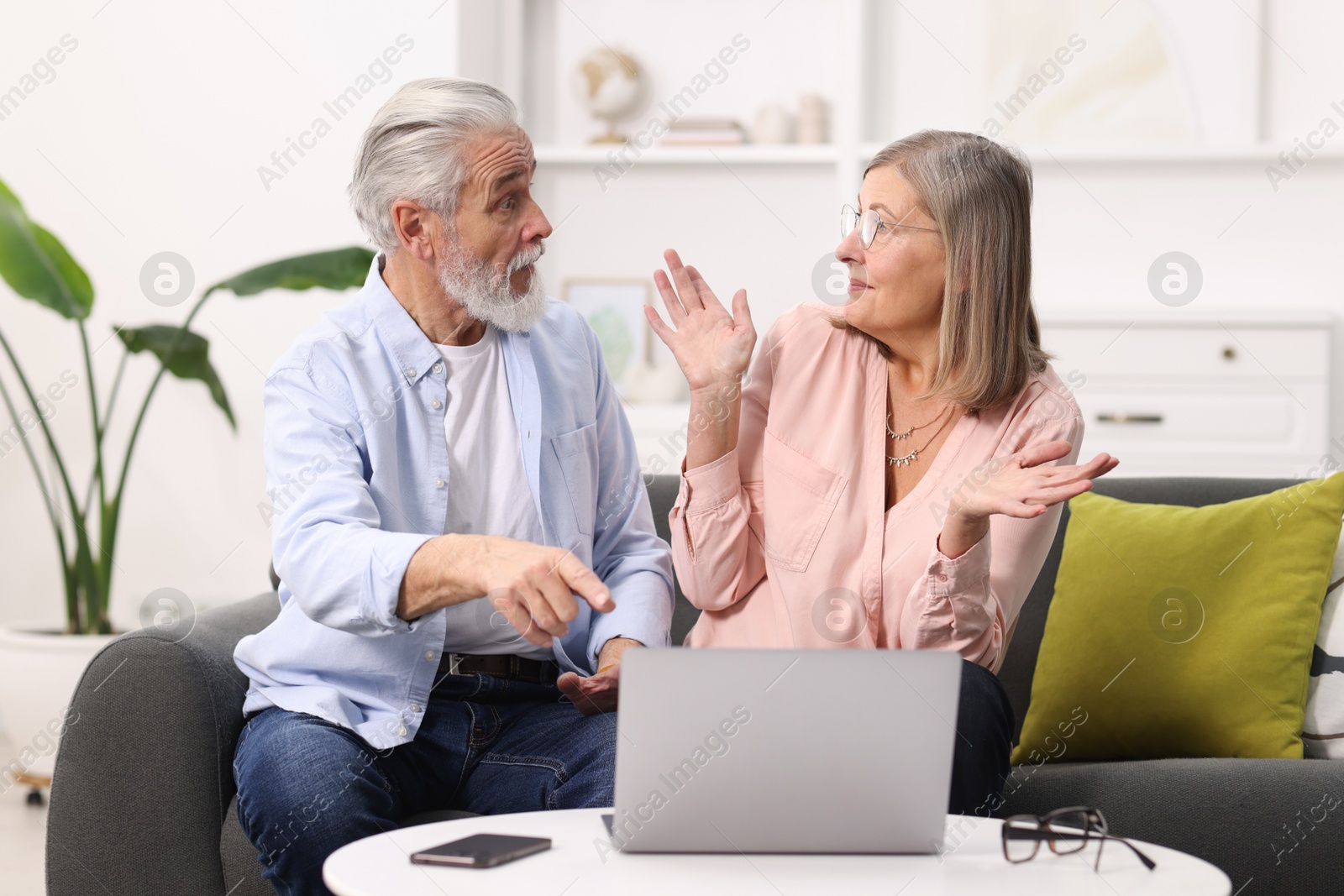 Photo of Cute elderly couple spending time together on sofa at home