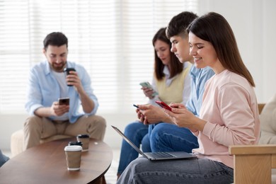 Internet addiction. Group of friends with gadgets and coffee at table indoors