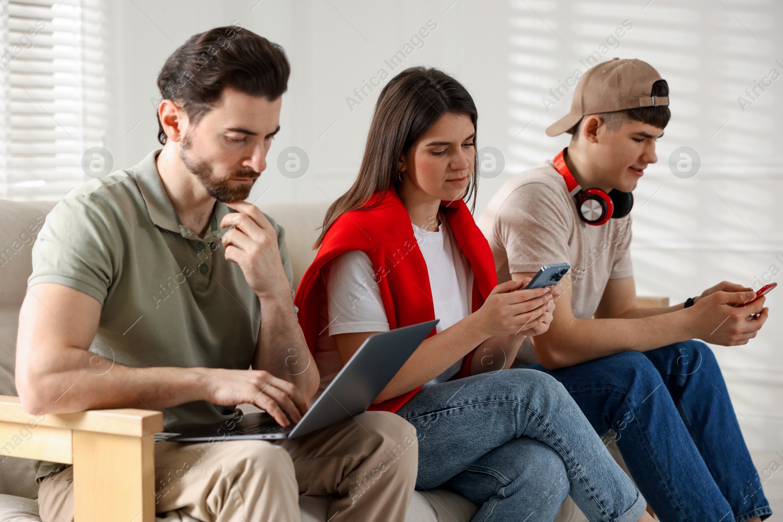 Photo of Internet addiction. Group of people with gadgets on sofa indoors