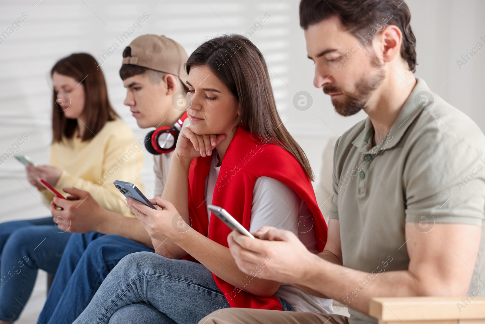 Photo of Internet addiction. Group of people with smartphones indoors