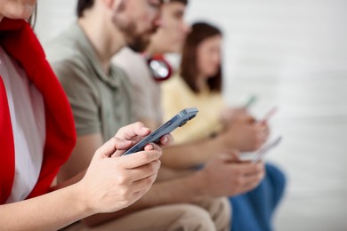 Photo of Internet addiction. Group of people with smartphones indoors, closeup