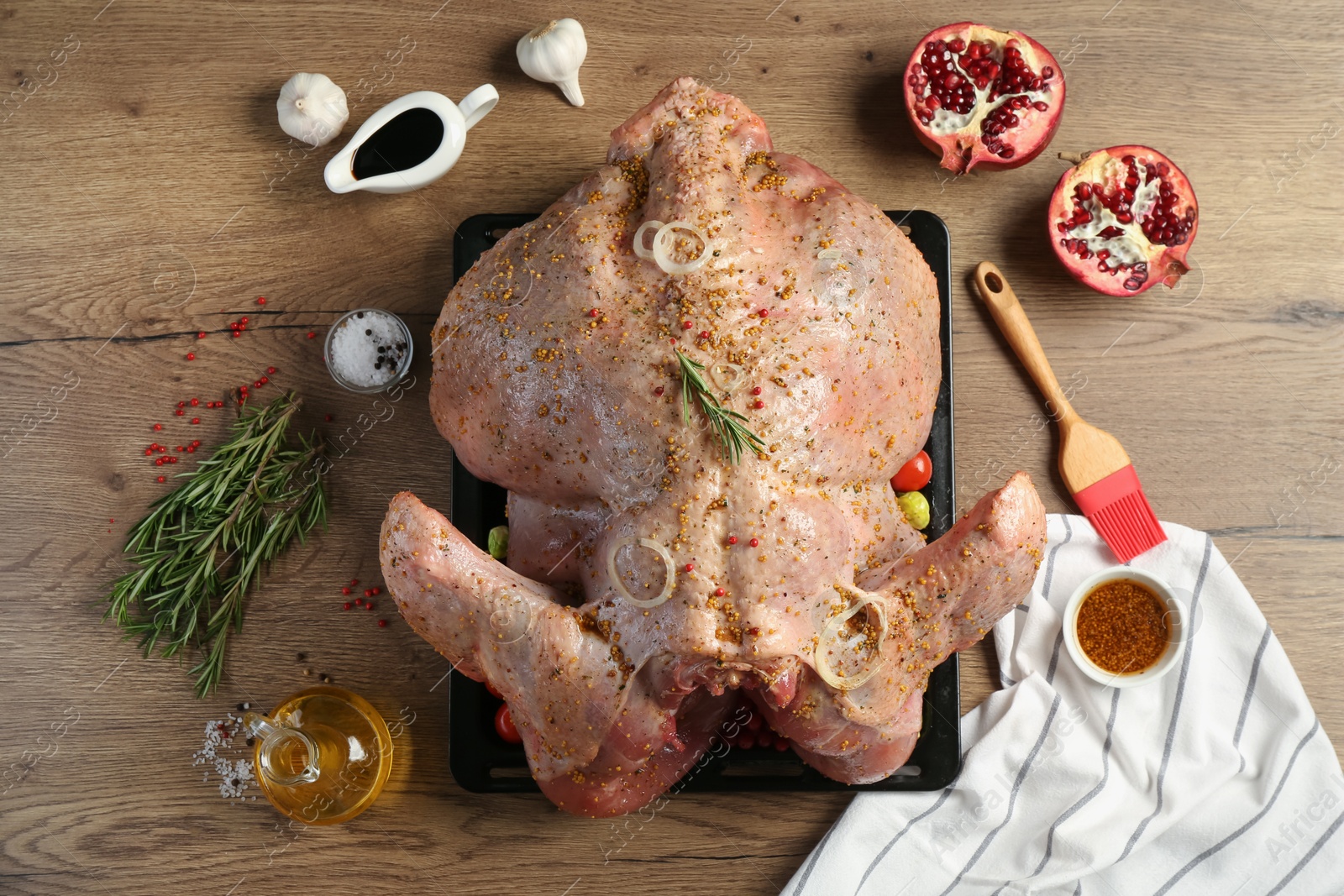 Photo of Whole raw turkey with ingredients for marinade on wooden table, flat lay