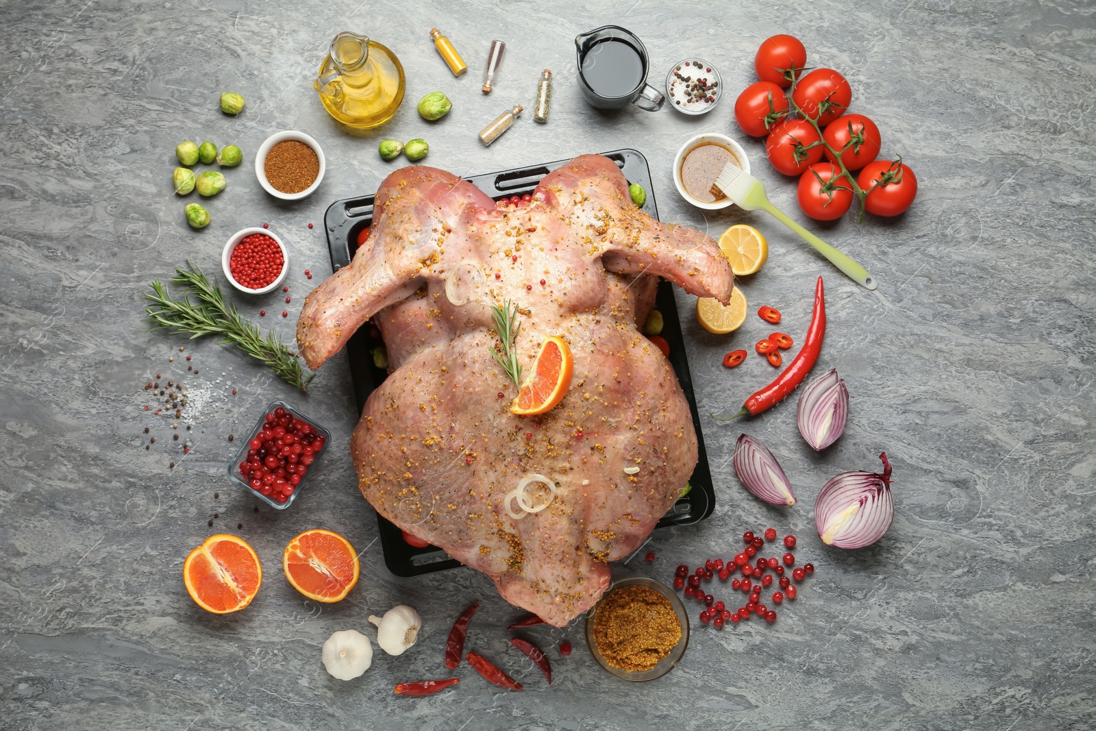 Photo of Whole raw turkey with ingredients for marinade on grey table, flat lay