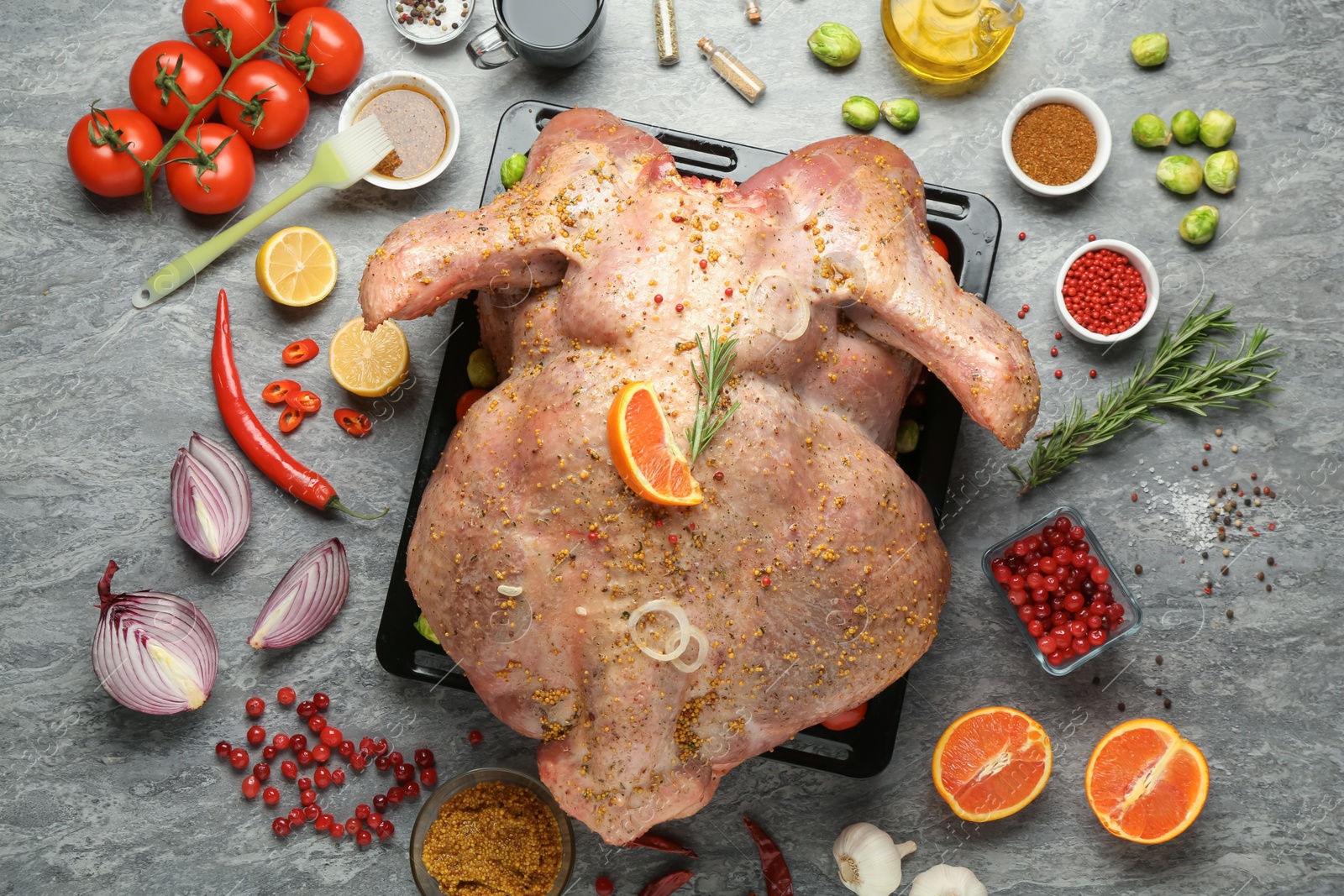 Photo of Whole raw turkey with ingredients for marinade on grey table, flat lay