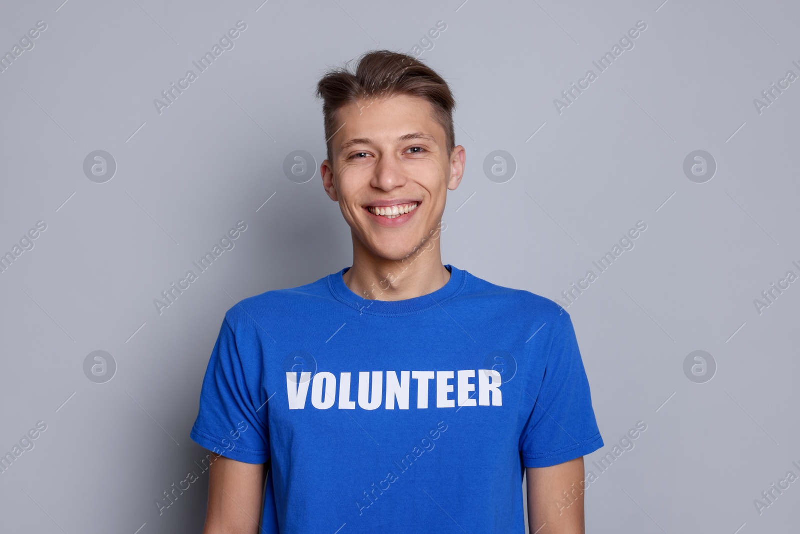 Photo of Portrait of smiling volunteer on grey background