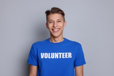 Portrait of smiling volunteer on grey background