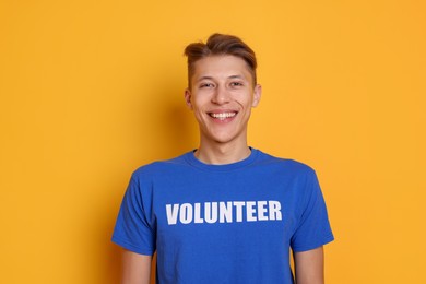 Photo of Portrait of smiling volunteer on orange background