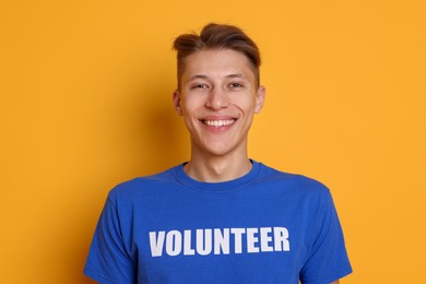 Photo of Portrait of smiling volunteer on orange background