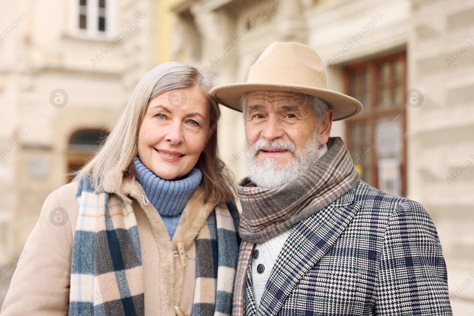 Photo of Family portrait of happy elderly couple on city street